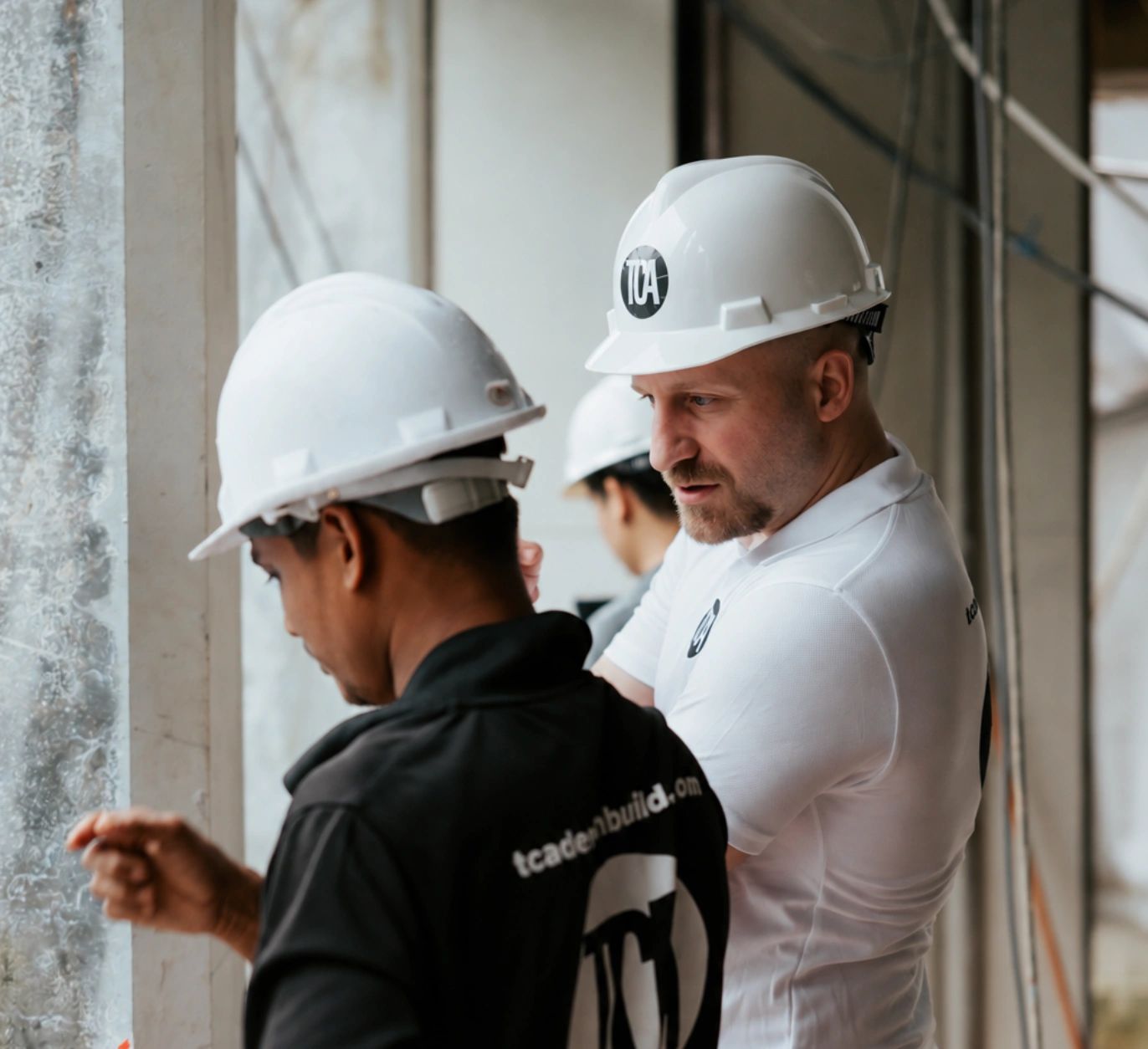Pier Alessio Rizzardi in a hard hat reviewing work with a site team member