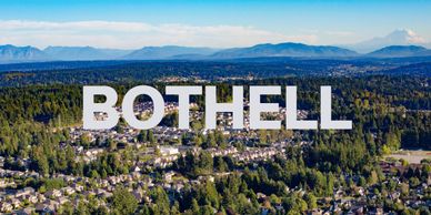 Aerial view of Bothell with houses and trees under a blue sky.