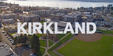Aerial view of Kirkland with park, buildings, and water in the background.
