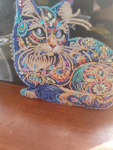 Colorful jeweled cat art piece with intricate patterns.