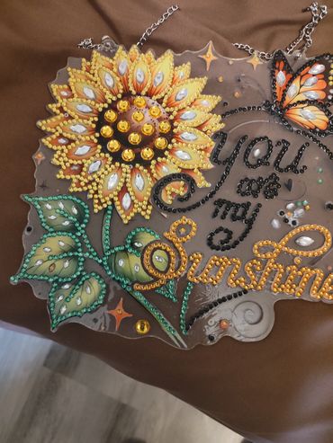 Decorative sunflower and butterfly artwork with the phrase 'You are my Sunshine'.