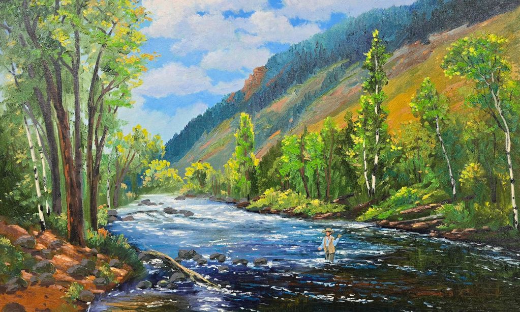 Man fly fishing in a river surrounded by lush green trees and mountains.