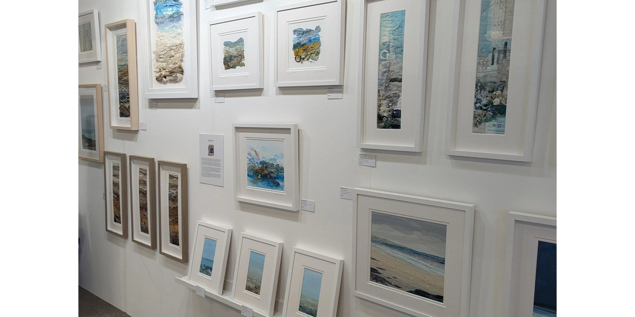 Alison's artwork displayed on the wall of her stand at an art show.