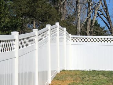 White vinyl fence with lattice top enclosing a grassy yard.
