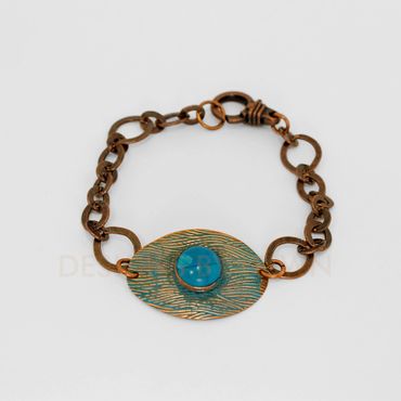 This ammonia patina copper bracelet is accented with a howlite cabochon.