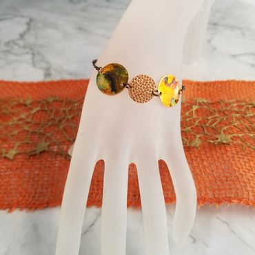 This copper disc bracelet is colored with alcohol ink.