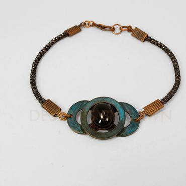 This copper washer bracelet has an ammonia patina finish with a black onyx accent,