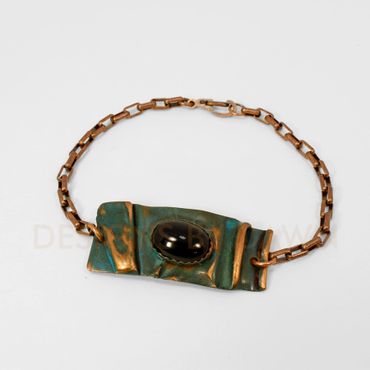 This folded copper bracelet has an ammonia patina and the ridges are sanded to create depth.