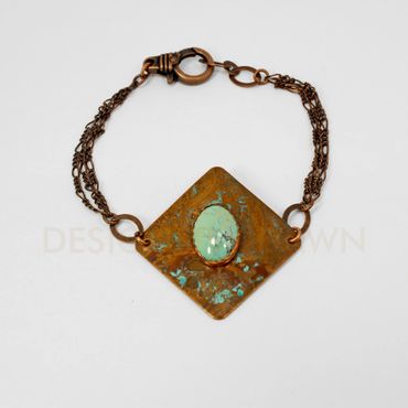 This square copper bracelet has a vinegar patina finish and a turquoise to accent it.