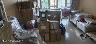 Furniture and boxes wrapped in plastic, ready for moving.