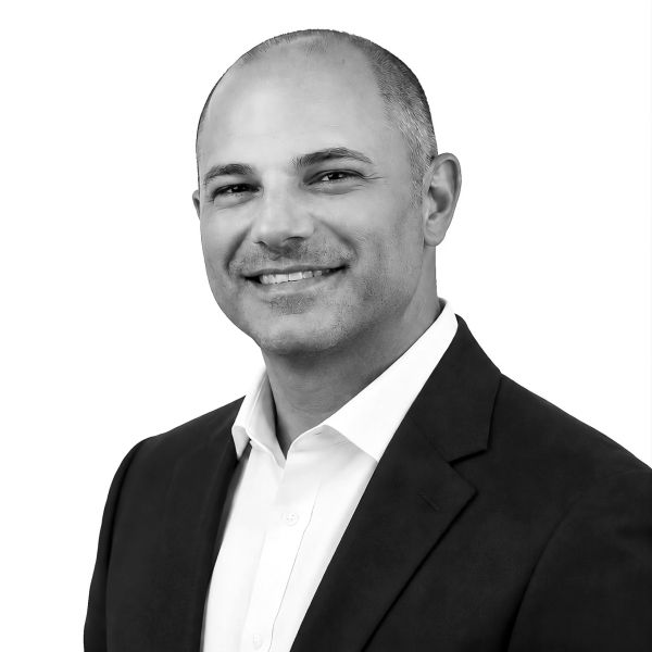 Smiling bald man in a suit jacket and white shirt.