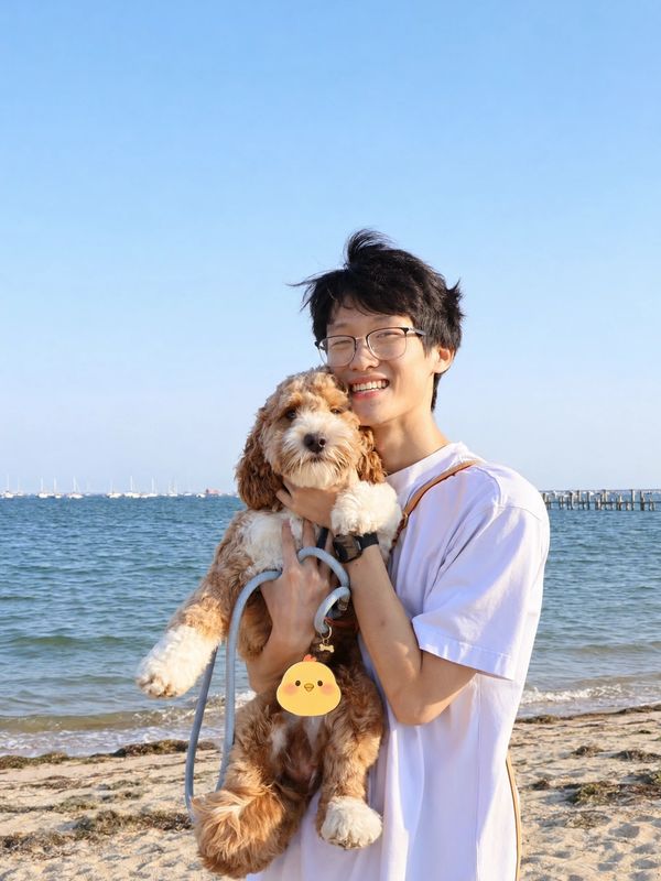 Person hugging a fluffy dog at the beach.