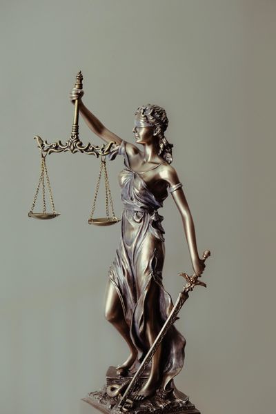 estatua de la justicia ciega , con una espada en la mano izquierda y en la derecha un peso.