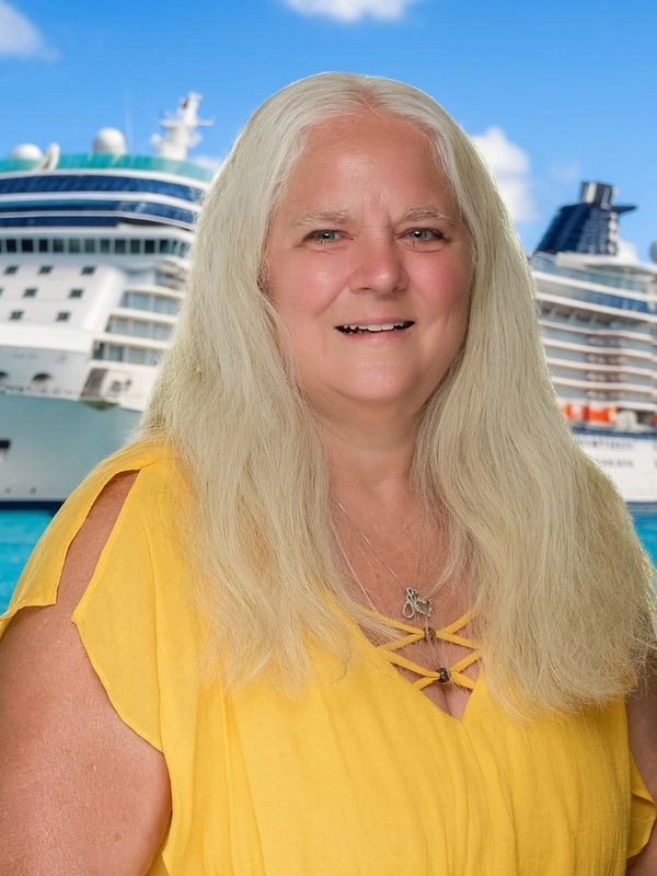 Smiling woman in a yellow dress with cruise ships in the background at a sunny dock.
