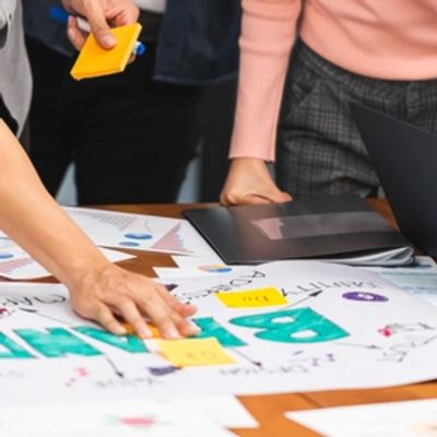 Young Asian creative team work together in business brand design project brainstorm meeting.