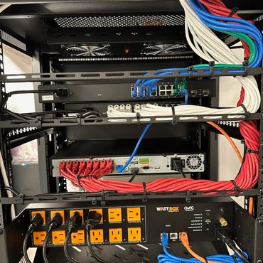 Organized network and power equipment in a server rack with colorful cables.