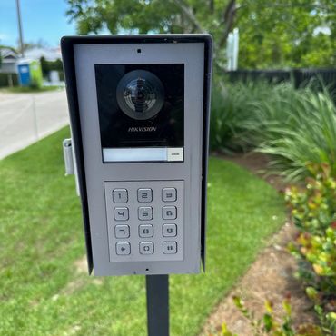 Hikvision access control keypad and camera on a post outdoors.