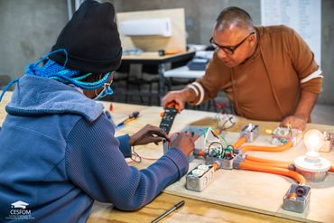 Estudiante del taller de electricidad midiendo voltajes de un circuito de practica. ©CESFOM 2023