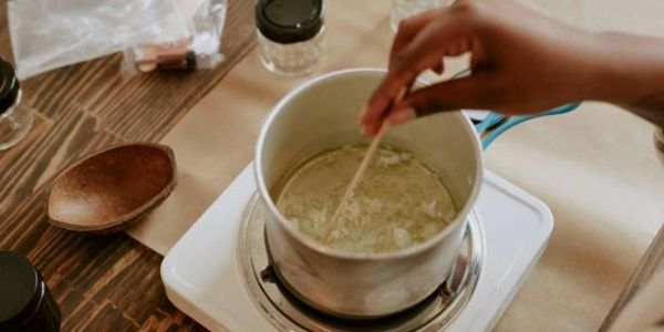 Hand stirring pot on a portable stove.