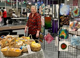 Debbie at Woodinville craft fair with homemade soap and acrylic pour art paintings.