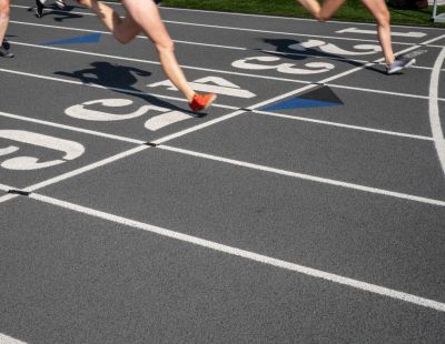 Runners crossing the finish line during a track race.