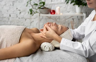 Woman receiving a relaxing facial massage in a spa setting.