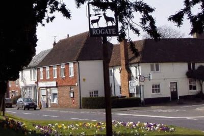 Village scene with Rogate sign and houses.