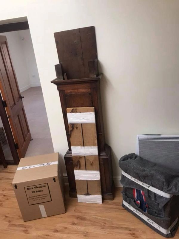 Packed belongings in a room with wooden floor.