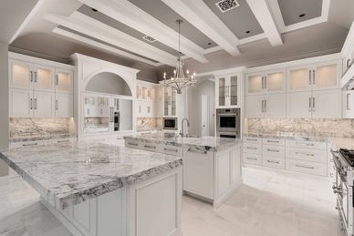 Luxurious kitchen with marble countertops and white cabinetry.