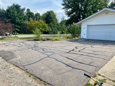 Crack filling on the driveway before seal coating in Sparta, MI