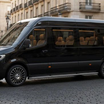 A sleek black luxury passenger van parked on a city street.