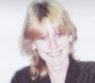 Smiling person with blonde hair and black outfit.