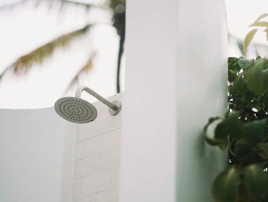 outdoor shower, modern design, minimalist, tropical living, home renovation, exterior bathroom, open-air shower, nature-inspired design, Pina Projects.