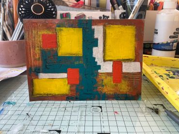 Abstract painting on a workspace grid mat.