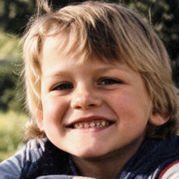 Smiling blonde boy outdoors.