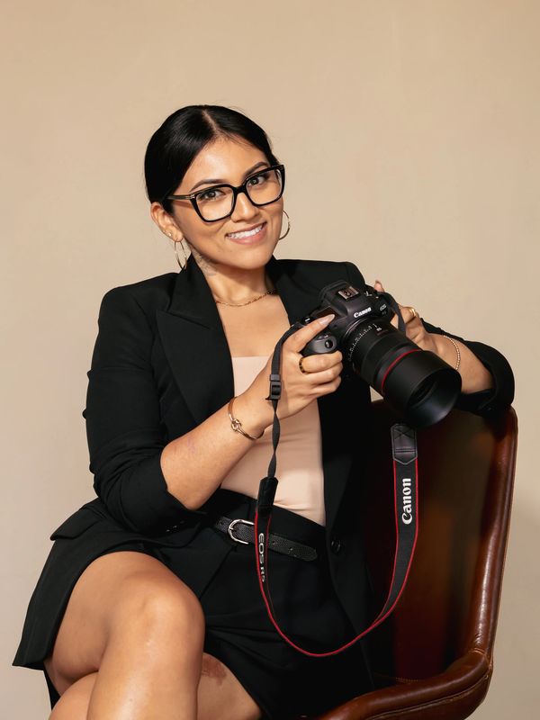 Woman with camera smiling at the viewer.