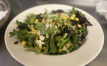 Tropical Salad, Mixed greens, mango cubs, avocado, corn, queso fresco tossed with mango vinaigrette