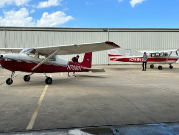 Two small airplanes parked on an airfield.