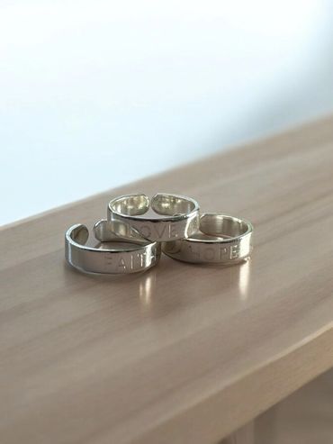 our faith, hope, and love rings in saintly silver