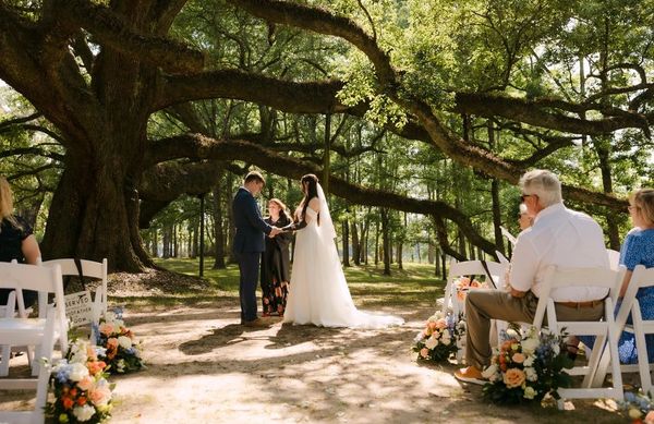Romantic outdoor ceremony beneath Live Oak trees in rolling hills at Kentwood Louisiana venue