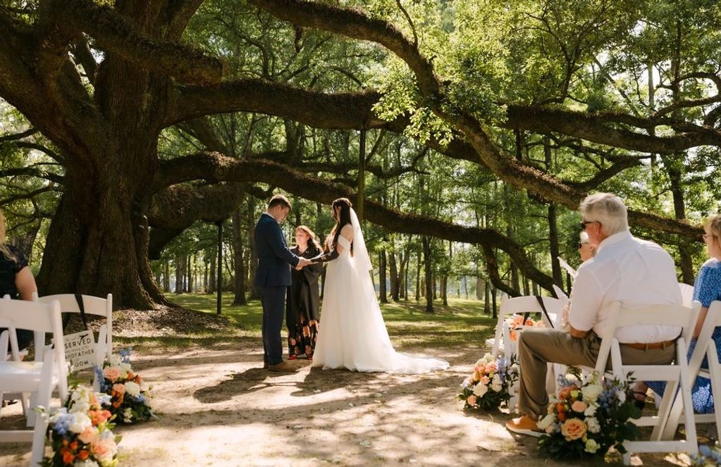 Couple exchanging vows under Live Oak trees at Kentwood Louisiana outdoor wedding venue