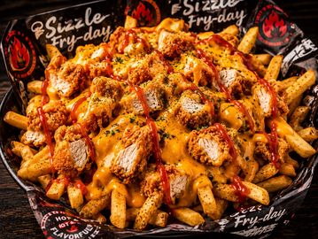 Loaded fries topped with crispy chicken, cheese sauce, and ketchup.