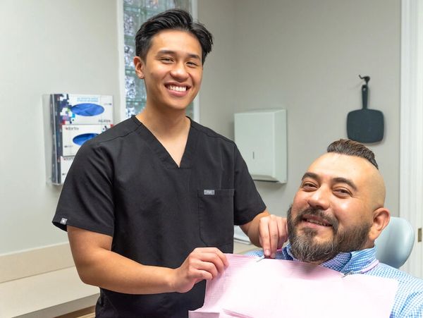 Staff member smiling and helping to prepare a patient for treatment
