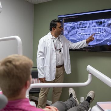 Dr. Ummareddy pointing and showing x-rays to a patient