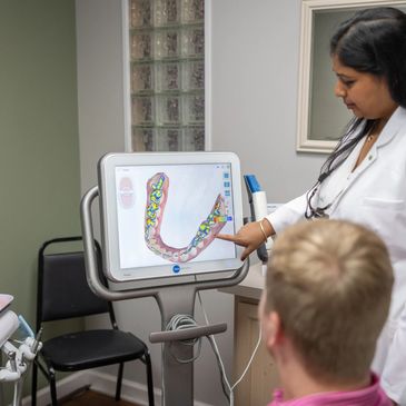 Dr. Gundarpi displaying a 3D model of teeth on a screen for a patient