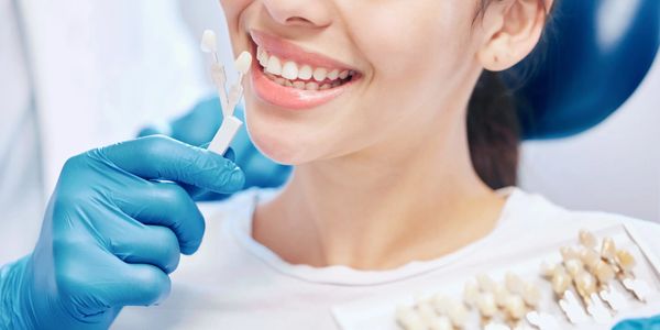 patient getting their teeth color-matched for dental crowns