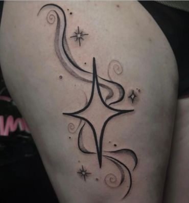 Abstract star with swirls tattoo on skin.