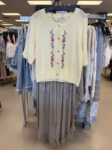 Yellow knit cardigan with floral embroidery and a gray ruffled skirt at The Peak in Albertville, MN