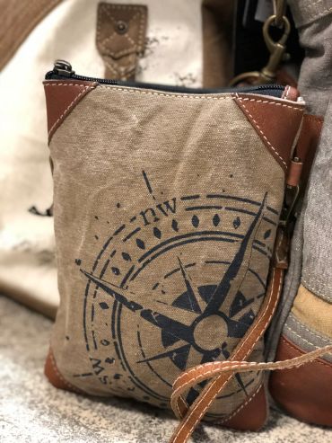 Close-up of a canvas and leather pouch with a compass design at The Peak in Albertville, MN