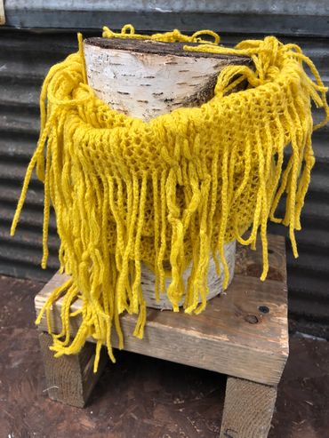 Yellow knitted scarf on a piece of log at The Peak in Albertville, MN